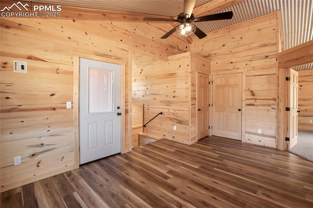 Image 32 of 45: Upstairs walk out family room featuring pine paneling, LVP flooring, and a 