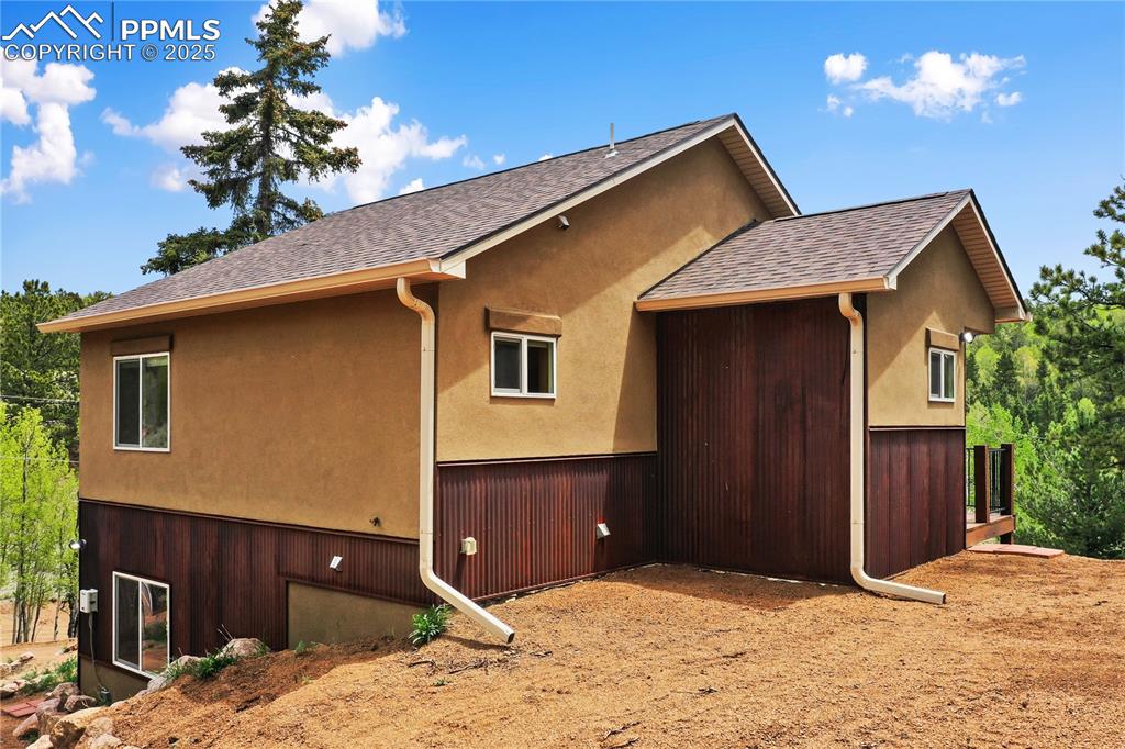 Image 7 of 45: View of property exterior with a shingled roof and stucco siding