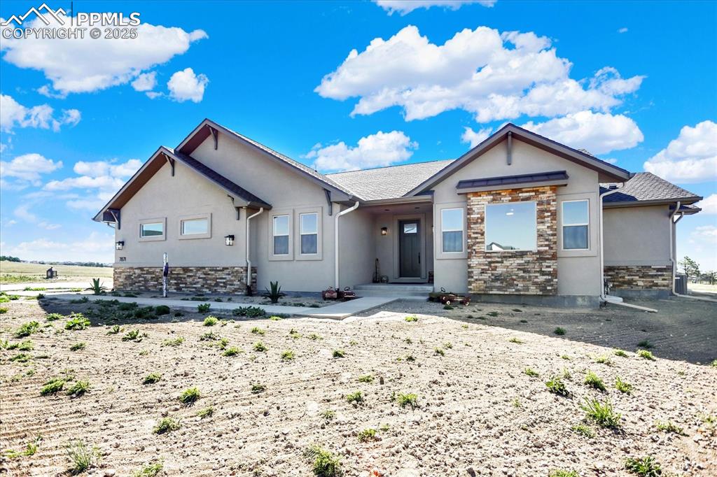 Image 37 of 50: Ranch-style house featuring stone siding and stucco siding