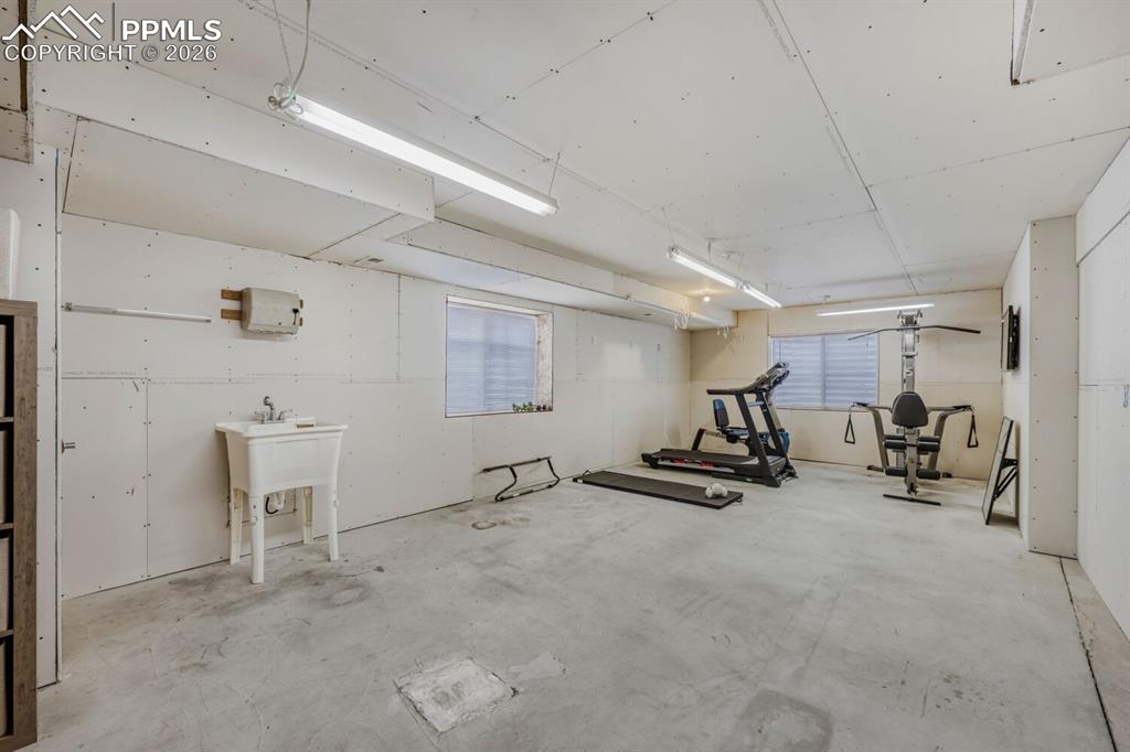 Image 37 of 50: Workshop, Currently used as home gym. In this model of home it was a Junior