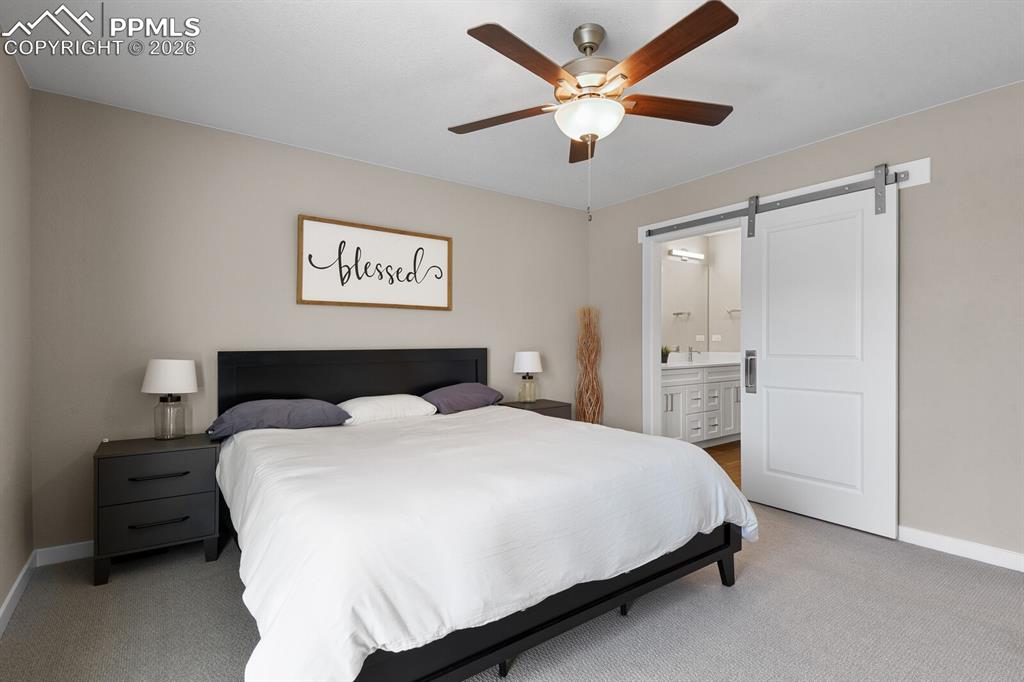 Image 17 of 34: Primary Suite With Barn Door Into Bath