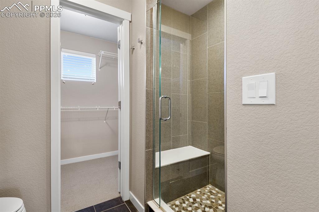 Image 20 of 34: Primary Suite Shower With Bench