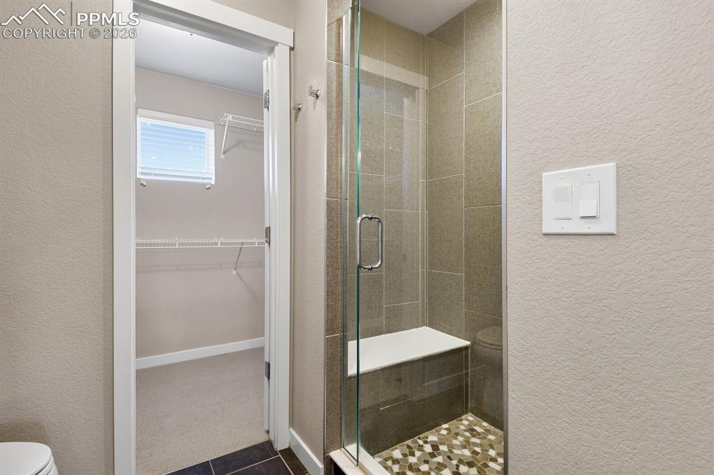 Image 21 of 35: Primary Suite Shower With Bench
