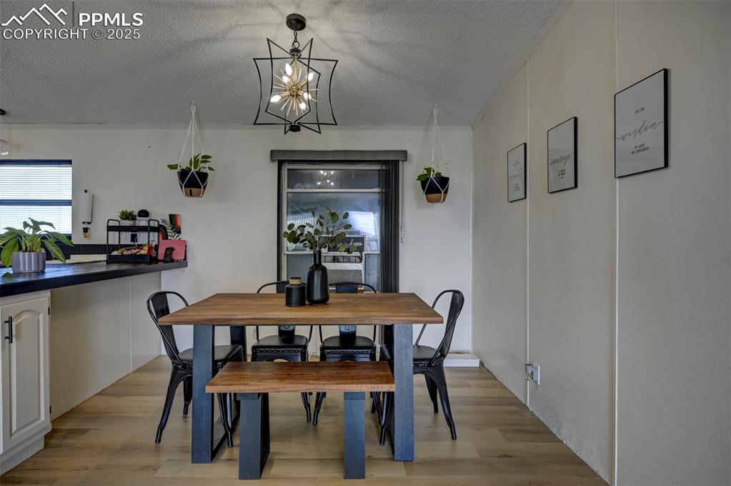 Image 13 of 40: Dining room featuring a textured ceiling, light wood-style flooring, and a