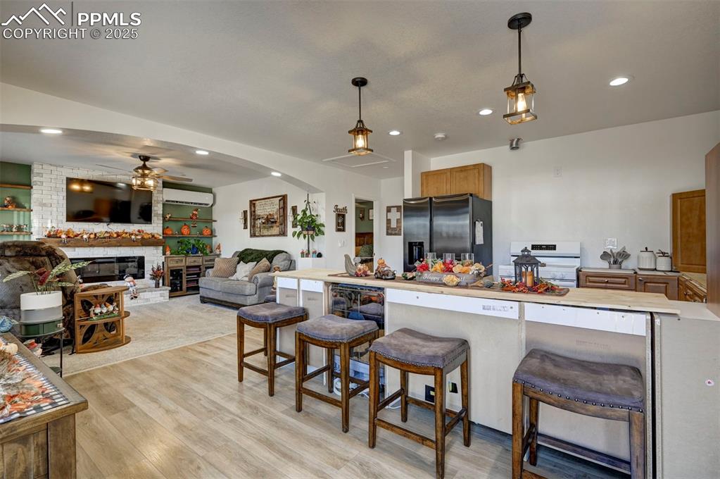 Image 26 of 40: Kitchen with a breakfast bar area, stainless steel fridge, recessed lightin