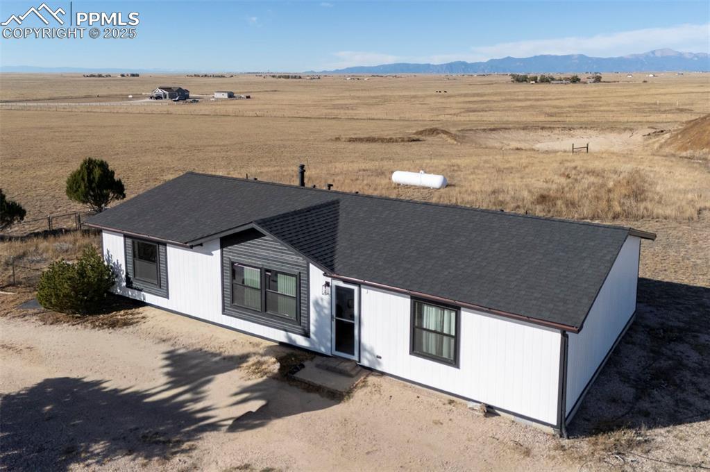 Image 3 of 40: Single story home with a view of countryside, roof with shingles, and a mou