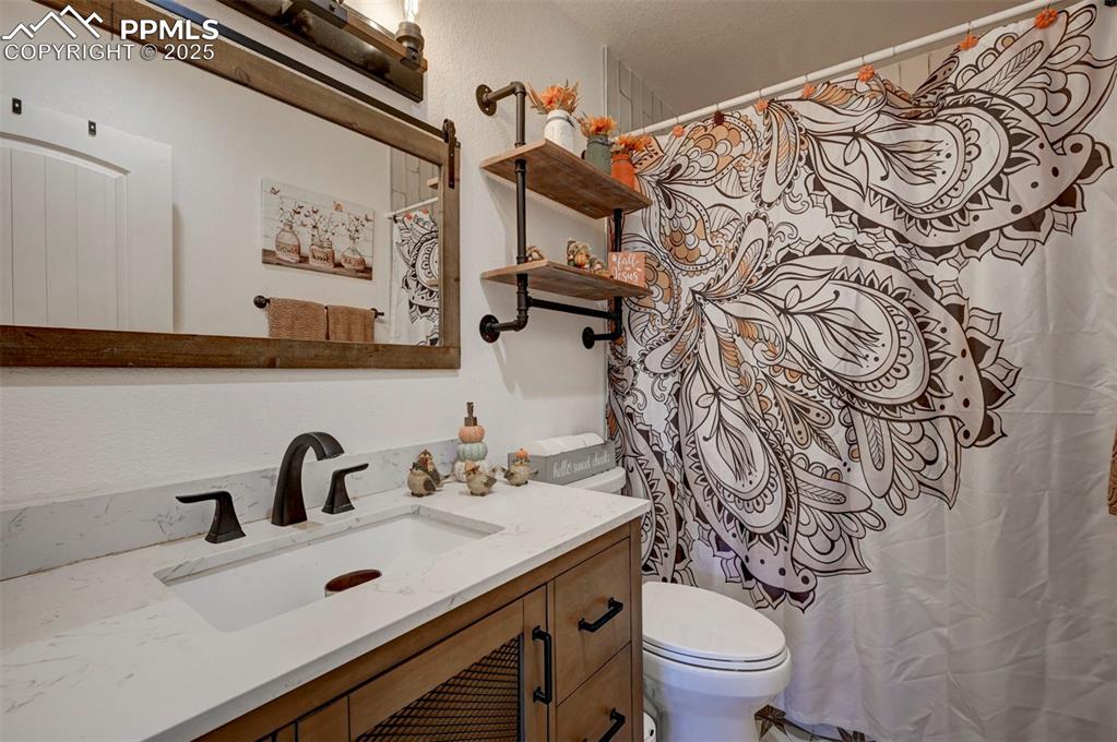 Image 35 of 40: Bathroom featuring a shower with curtain and vanity