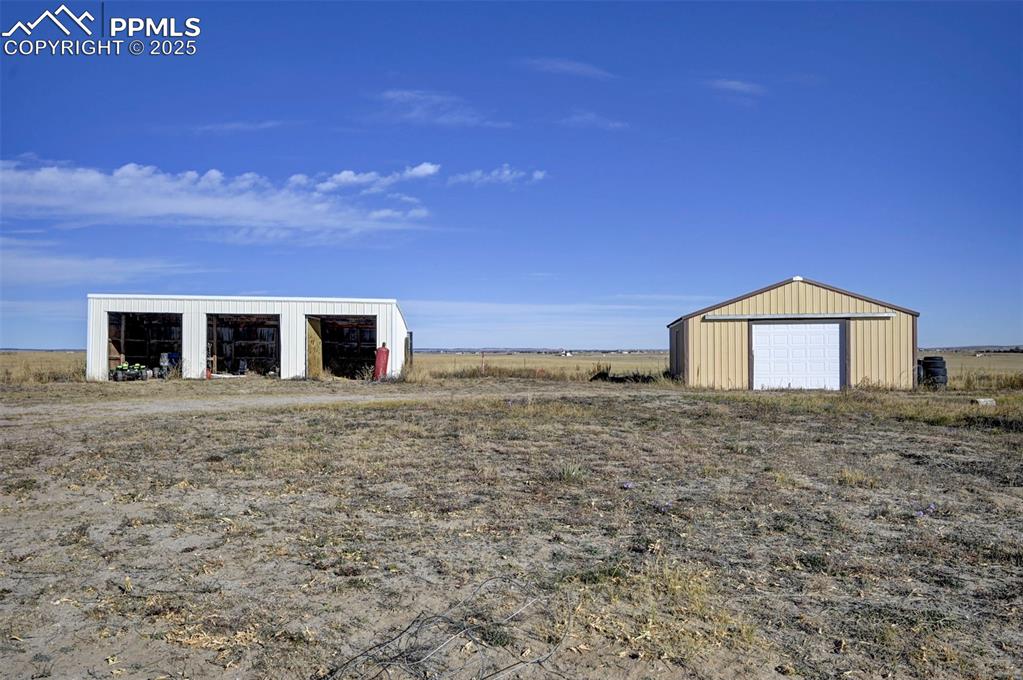 Image 37 of 40: View of yard featuring an outbuilding, a garage, and a rural view