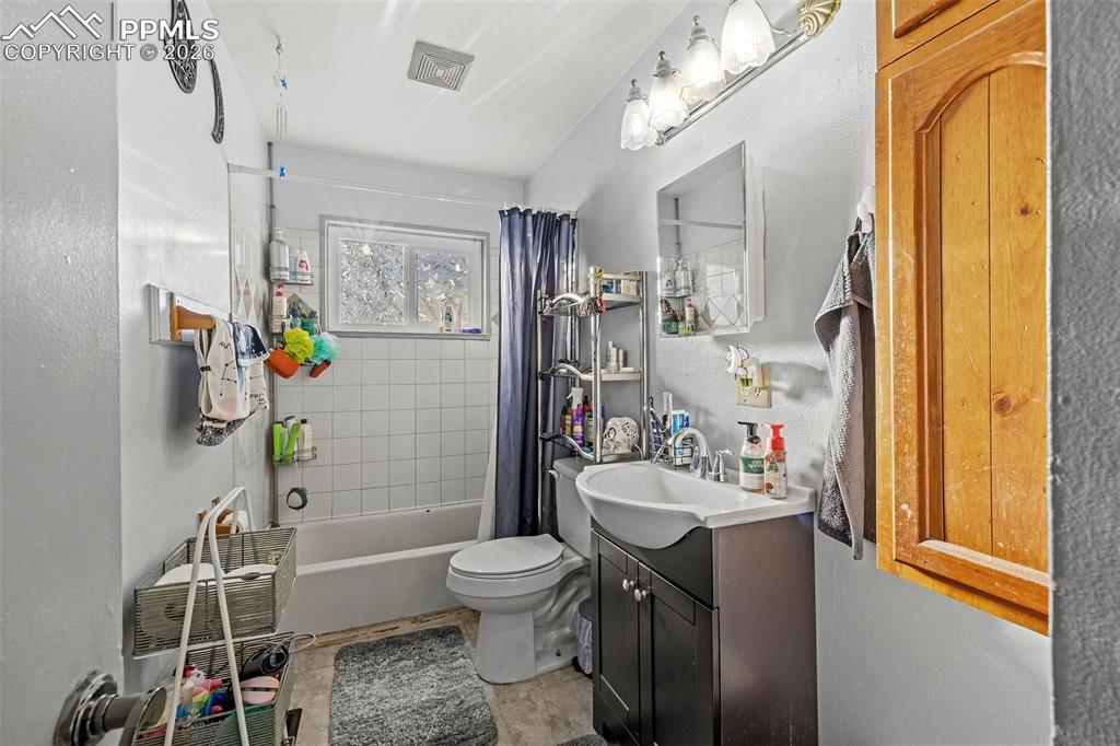 Image 13 of 19: Bathroom featuring vanity and shower / tub combo with curtain