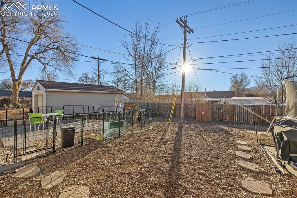 Image 19 of 19: Fenced backyard featuring a garden