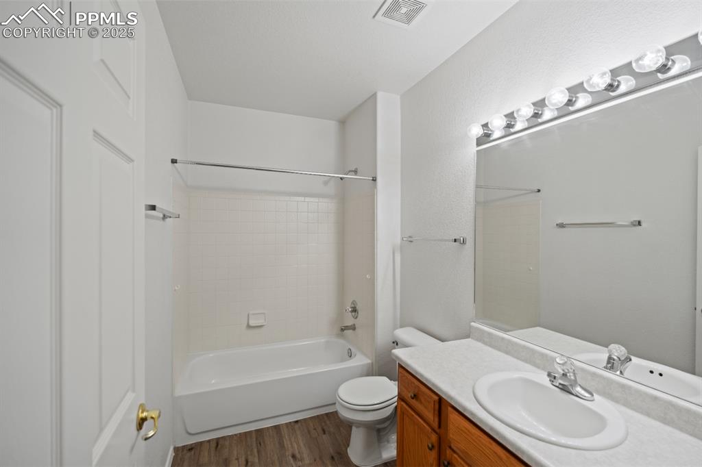 Image 15 of 22: Bathroom with vanity, wood finished floors, and shower combination