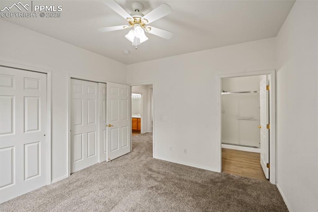 Image 16 of 22: Unfurnished bedroom featuring carpet flooring, multiple closets, ensuite ba