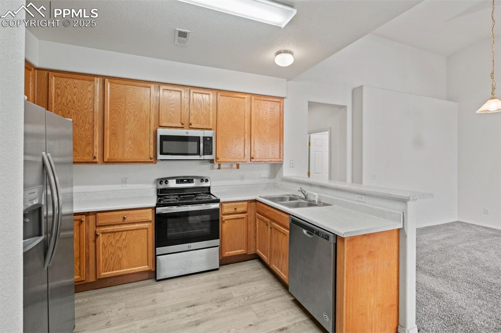 Image 7 of 22: Kitchen featuring stainless steel appliances, a peninsula, light countertop