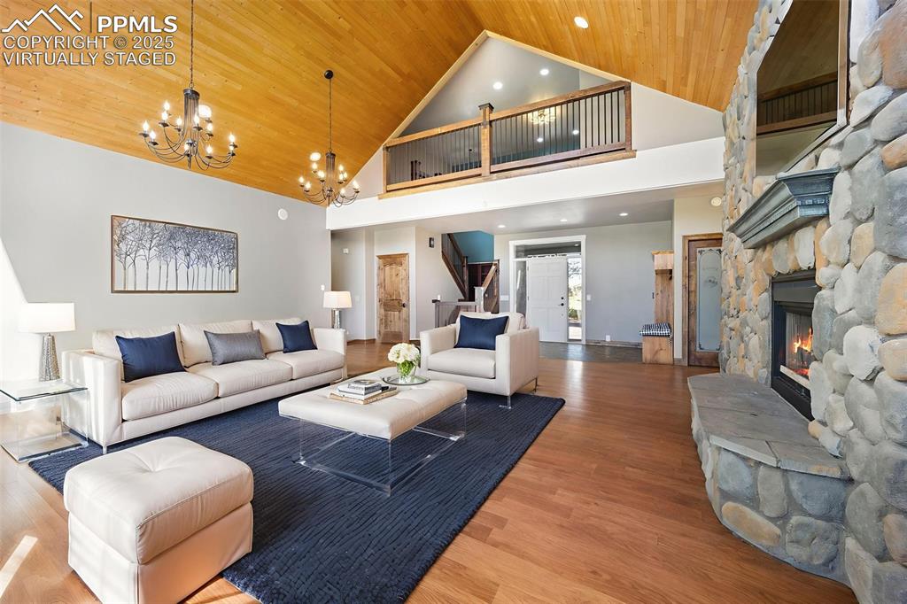 Image 15 of 50: Virtually Staged. Living area with high vaulted ceiling, wood finished floo