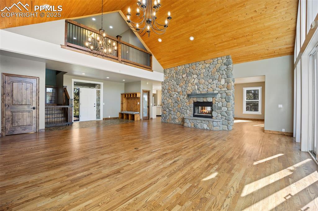 Image 18 of 50: Unfurnished living room with high vaulted ceiling, light wood-style floorin