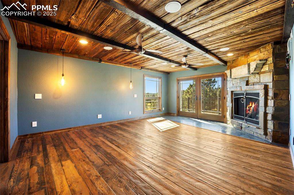 Image 21 of 50: Unfurnished living room with french doors, a ceiling fan, a wooden ceiling