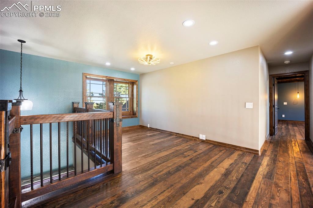 Image 28 of 50: Unfurnished room with dark wood-style floors and recessed lighting