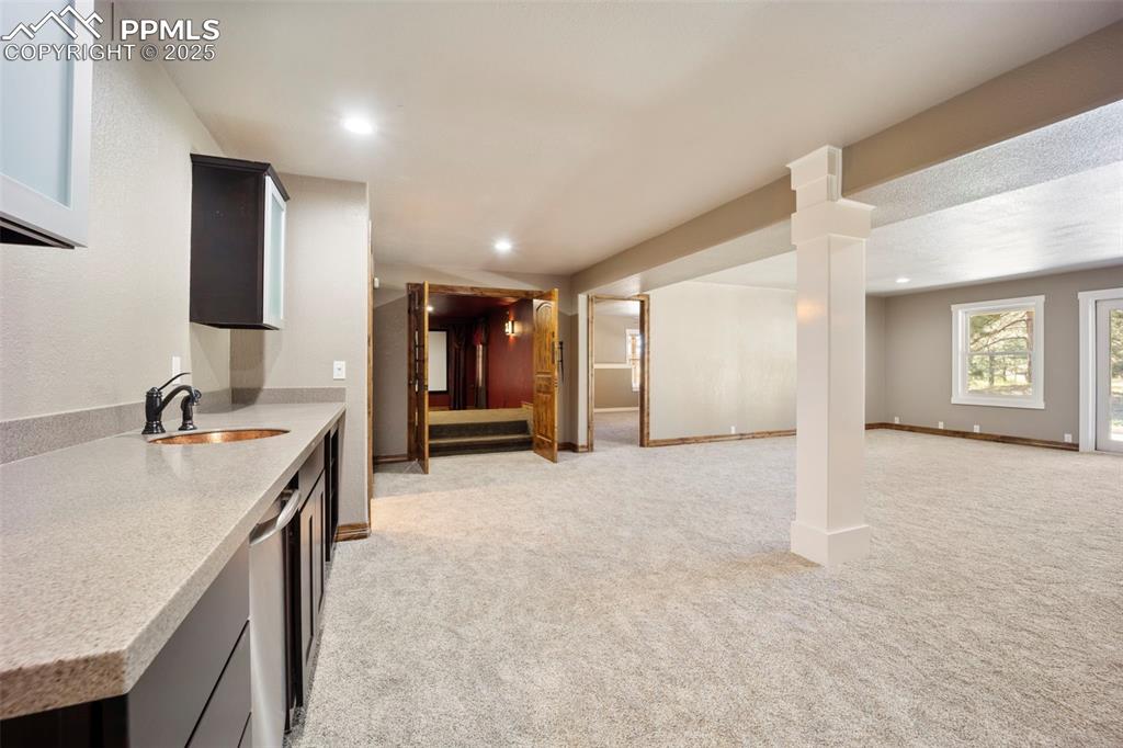 Image 31 of 50: Kitchen with light carpet, light stone countertops, open floor plan, recess