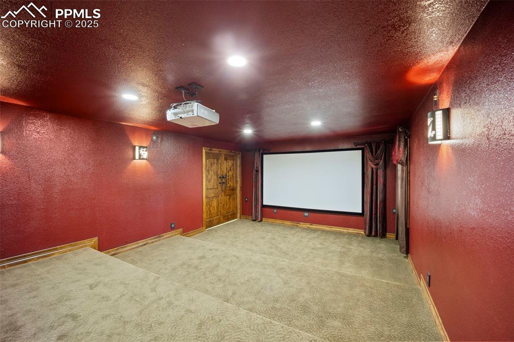 Image 32 of 50: Home theater with a textured wall, a textured ceiling, and light colored ca