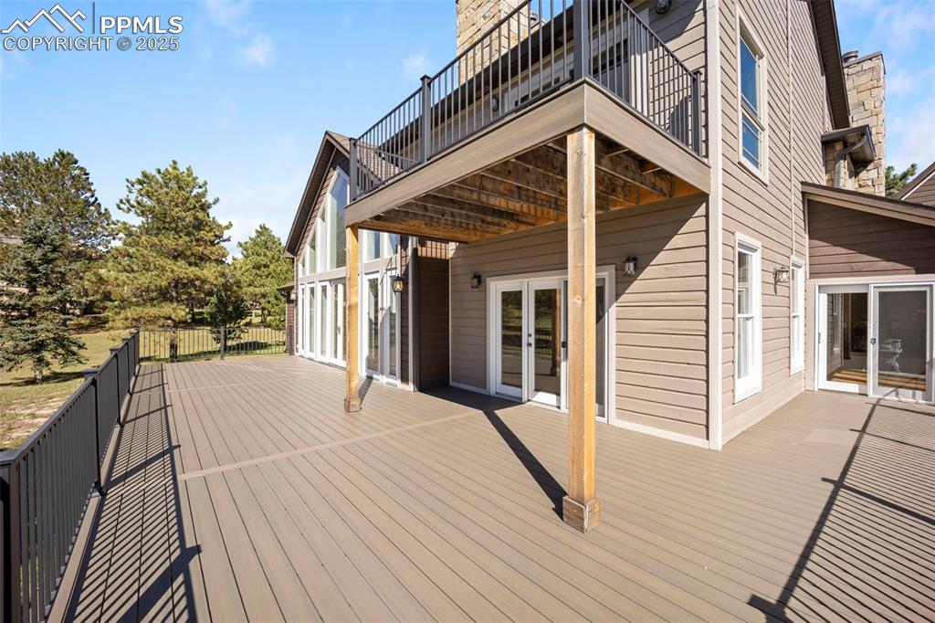 Image 48 of 50: Wooden terrace with french doors