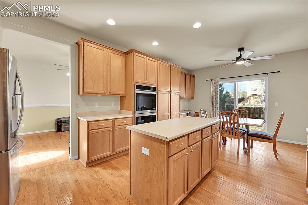 Image 11 of 44: Kitchen with a ceiling fan, stainless steel appliances, light countertops, 