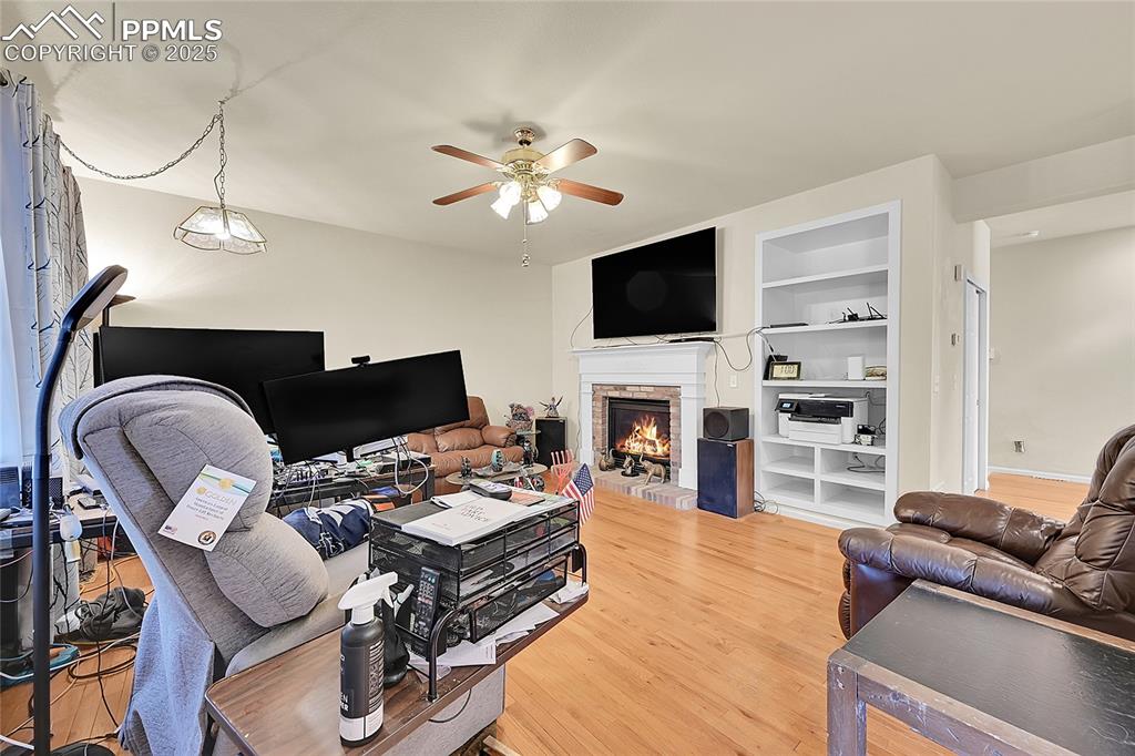 Image 16 of 44: Living area with a fireplace, light wood-style flooring, built in features,