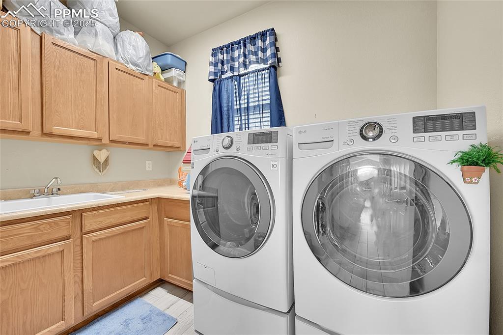 Image 20 of 44: Washroom featuring washer and clothes dryer and cabinet space