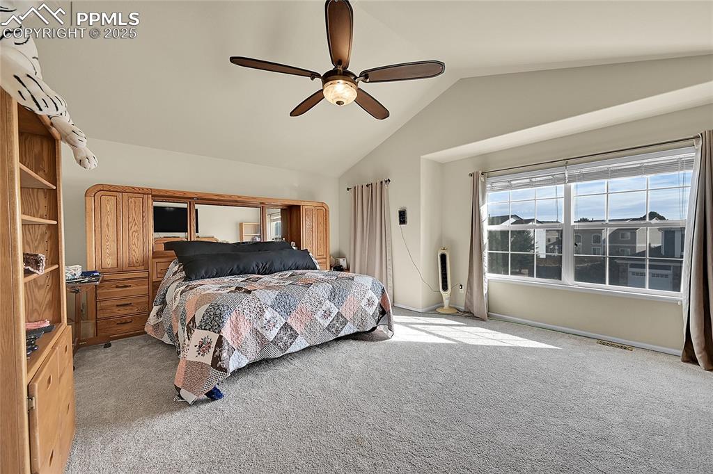 Image 21 of 44: Bedroom featuring lofted ceiling, light colored carpet, and a ceiling fan