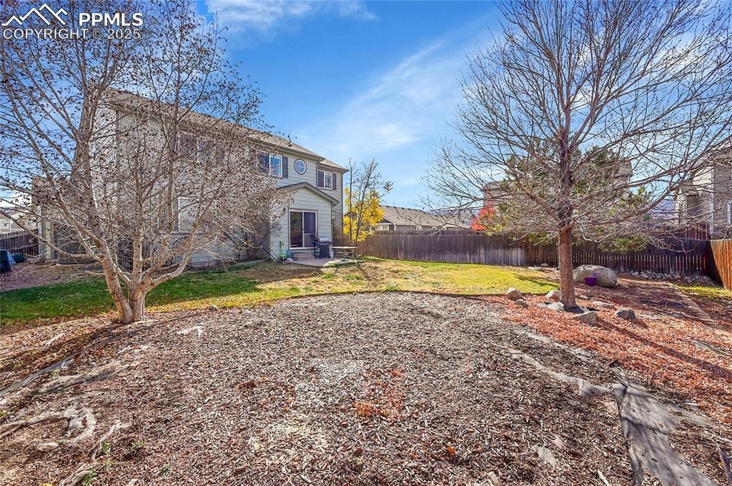 Image 32 of 44: Back of property with a fenced backyard and a patio