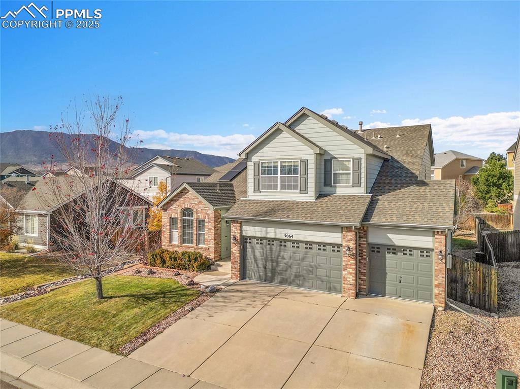 Image 34 of 44: View of front of property featuring brick siding, driveway, a shingled roof