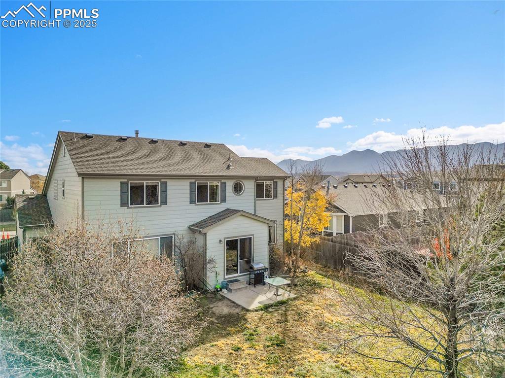 Image 36 of 44: Rear view of property featuring a patio, a mountain view, roof with shingle