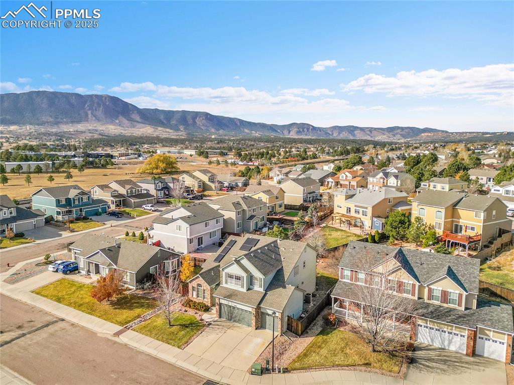 Image 38 of 44: Aerial view of residential area featuring a mountain backdrop