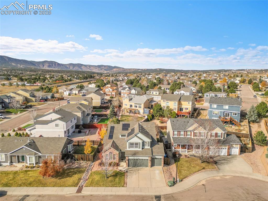 Image 39 of 44: Aerial perspective of suburban area with a mountain backdrop