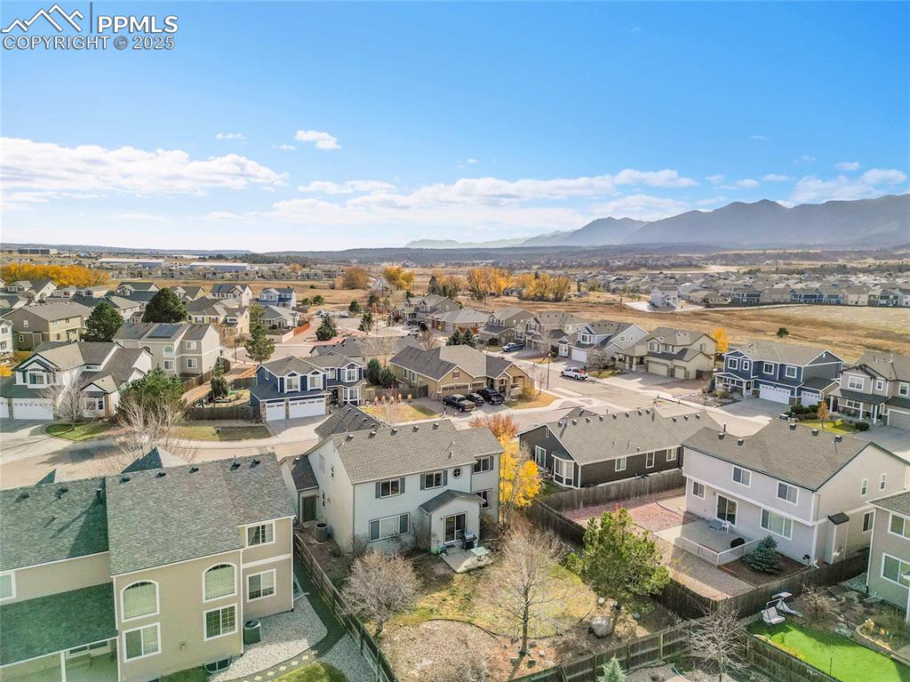 Image 40 of 44: Aerial view of residential area with a mountainous background