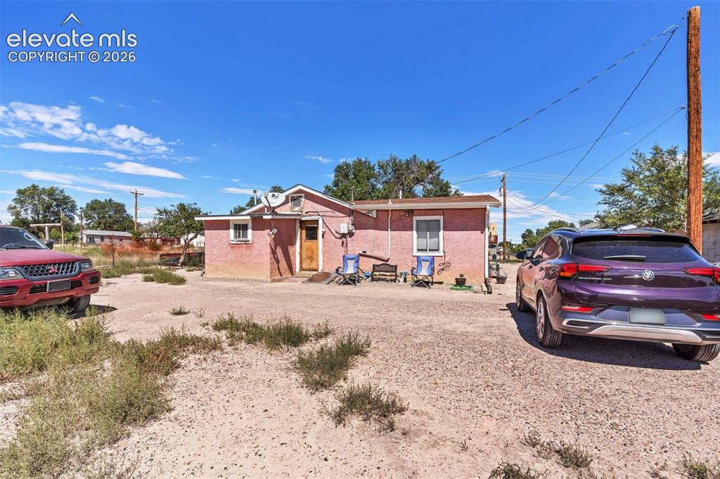 Image 1 of 29: Property exterior featuring a textured pink facade, multiple windows, a woo