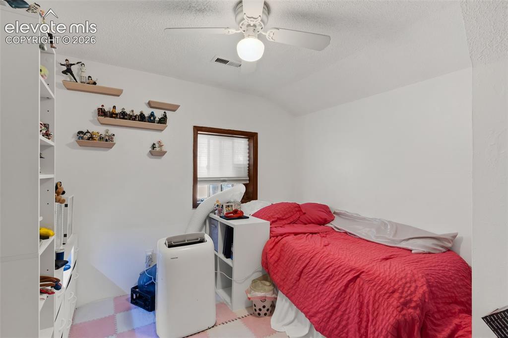 Image 14 of 29: White walls with textured ceiling and a ceiling fan