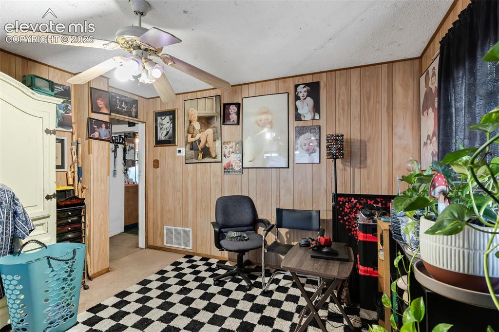 Image 2 of 29: Wood paneling throughout, ceiling fan with integrated lighting, and a neutr