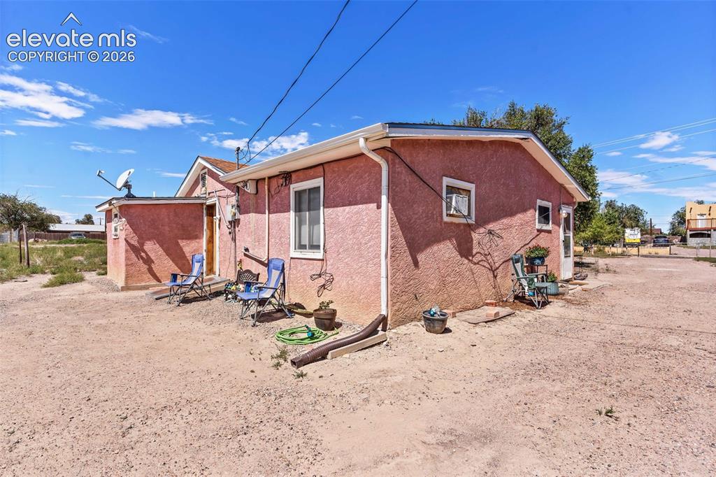 Image 22 of 29: Stucco exterior with a pitched roofline