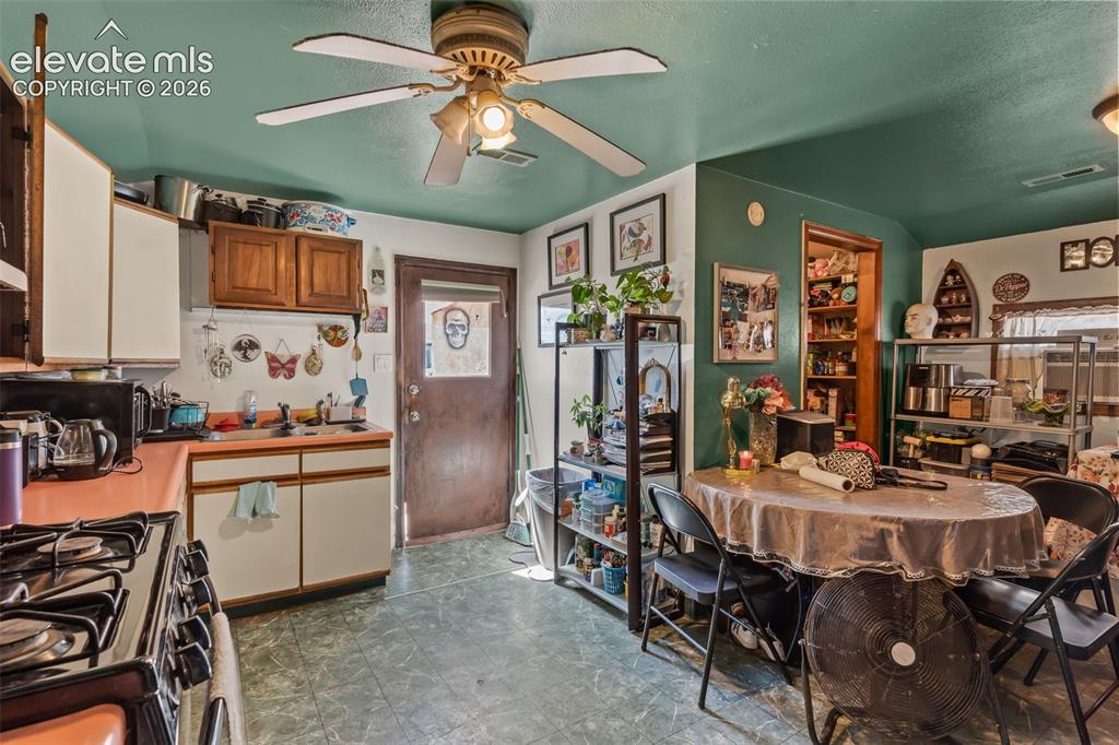 Image 6 of 29: Functional kitchen featuring a gas range, dual-basin sink, and a ceiling fa