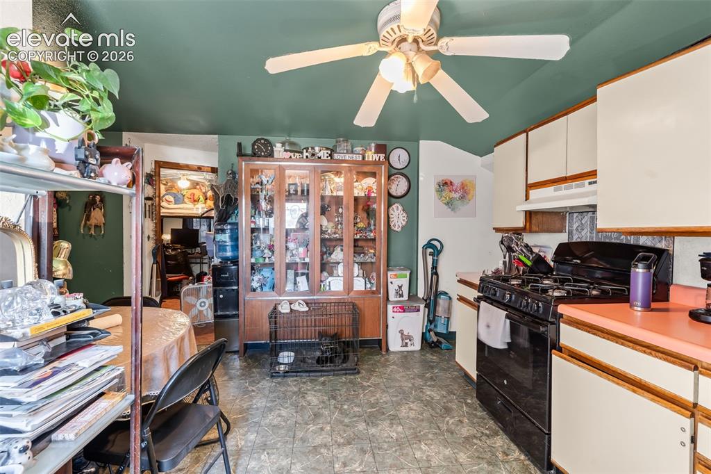 Image 8 of 29: Kitchen with a ceiling fan, white upper and lower cabinetry, a black gas ra