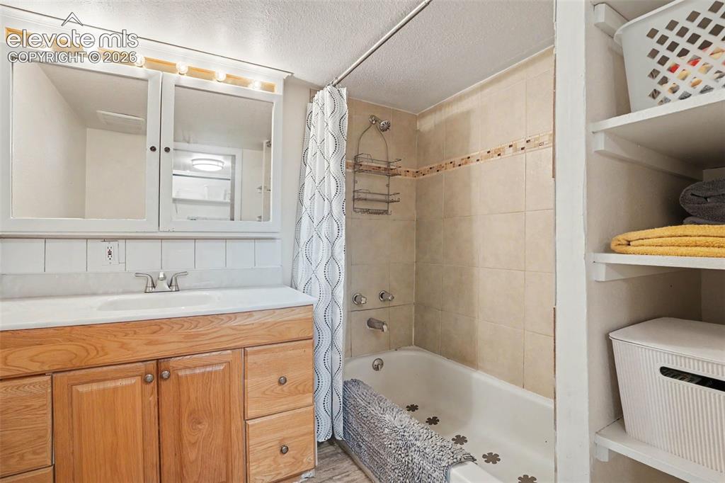 Image 11 of 24: Decorative tile accent in shower in this private bathroom next to the maste