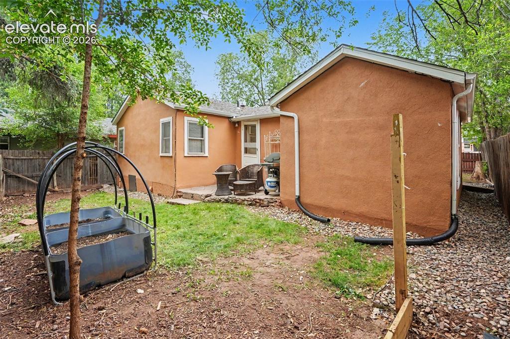 Image 18 of 24: Enjoy square foot gardening and a patio to grill on.