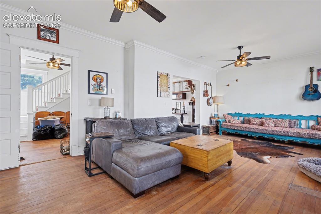 Image 13 of 43: Living / Dining area with ceiling fan, crown molding, hardwood, and large w