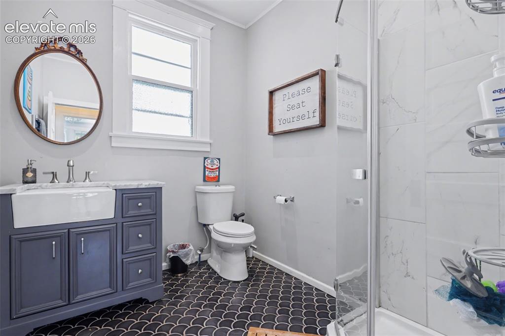 Image 18 of 43: Bathroom featuring vanity, a marble finish shower, and crown molding