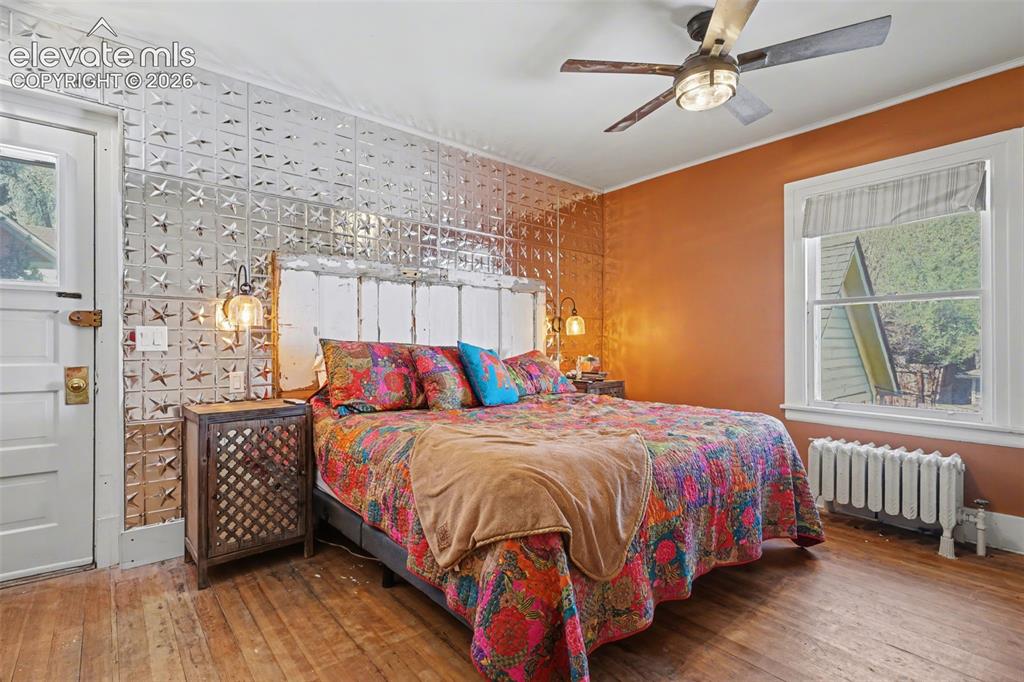 Image 21 of 43: Primary bedroom with hardwood flooring