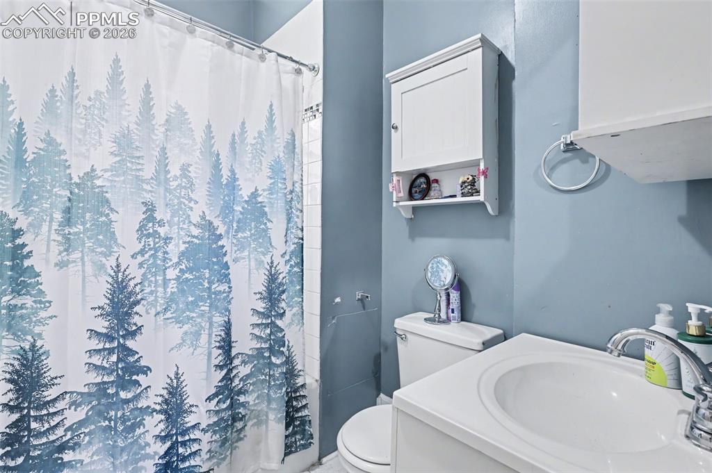 Image 32 of 46: Bathroom featuring curtained shower and vanity