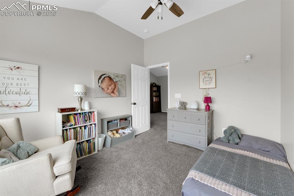 Image 23 of 39: Bedroom with carpet flooring, vaulted ceiling, and a ceiling fan