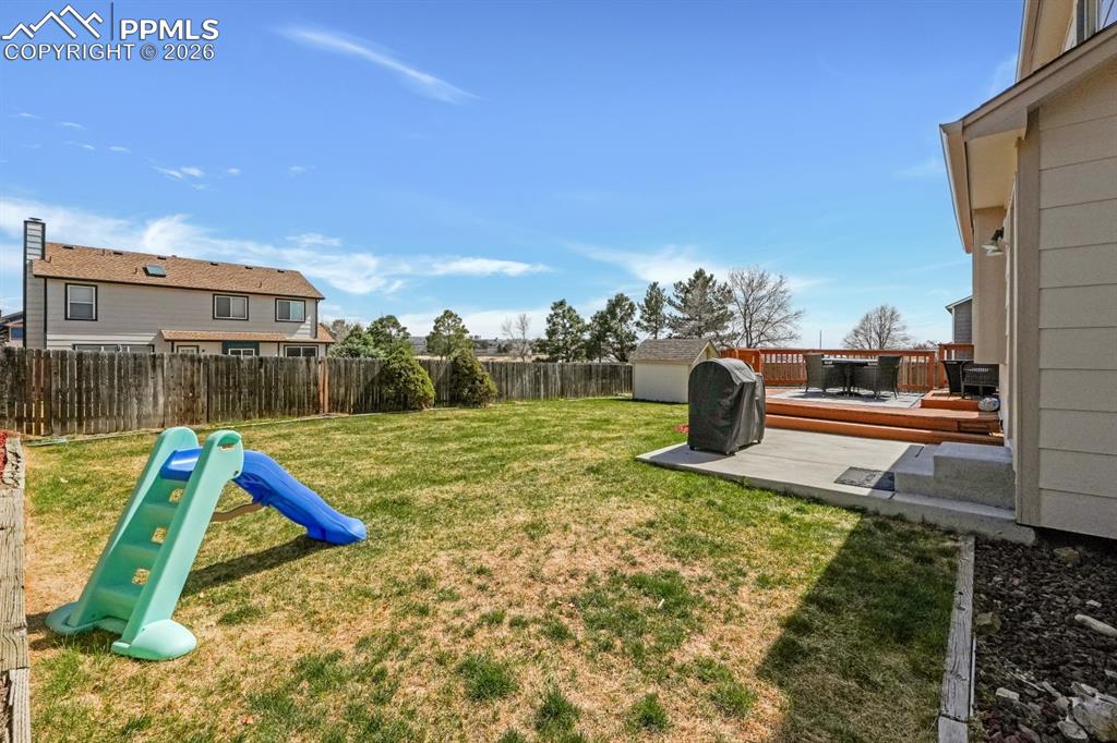 Image 31 of 39: Fenced backyard featuring a deck & patio