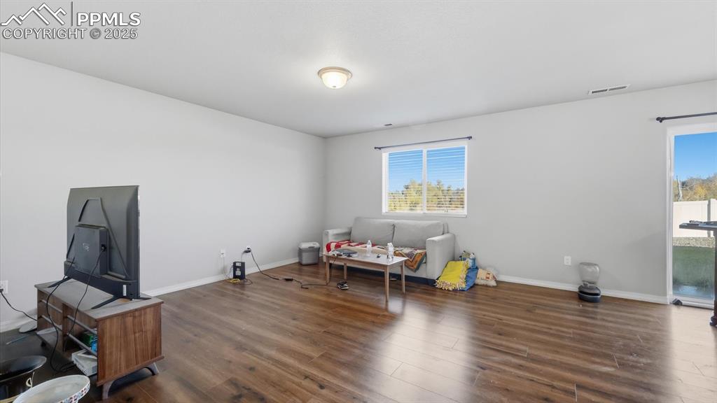 Image 11 of 36: Living Room with LVP flooring and view window to the backyard.