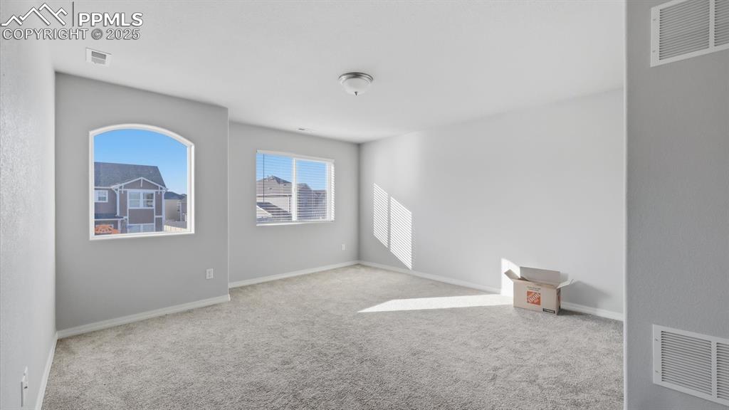 Image 16 of 36: Spacious upstairs loft with neutral carpet and windows that bring in lots o